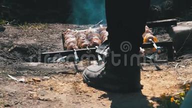 一个男人在乡下的一场大火上用烤肉串煮什什式烤肉串的腿的景色
