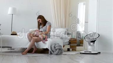 年轻的母亲抱着她新生的孩子。 妈妈在照顾<strong>宝宝</strong>。 女人和新<strong>出生</strong>的男孩在白色的卧室里放松。 母亲