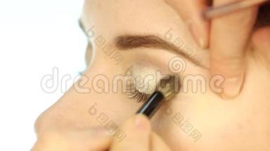 专业化妆师应用眼妆、阴影和眼线。 慢动作