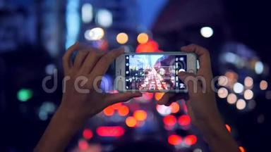 旅游妇女用手机拍摄夜间交通。 泰国曼谷。 4K慢运动。