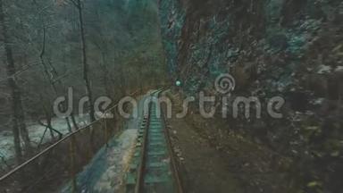 一列旧火车或火车头正沿着狭窄峡谷中的窄轨铁路行驶。 火车沿着火车行驶