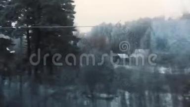 火车从窗口观看<strong>冬季</strong>雪林村<strong>房屋</strong>在雪。 冬天的森林透过窗户