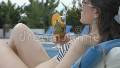 年<strong>轻放</strong>松的女士在海滩上喝鸡尾酒，享受假期