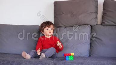 穿着红色毛衣坐在沙发上的滑稽小男孩