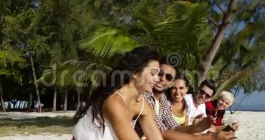 利用手机智能手机进行群体交流在线交谈，坐在棕榈树下户外