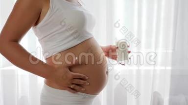 健康的营养，孕妇端着玻璃牛奶，慢动作地抚摸大肚子