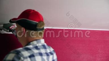 家庭改善。 戴红帽子的人用<strong>油漆</strong>滚筒和<strong>油漆</strong>刷给房间着色。