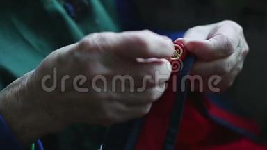 一个非常老的女人的手紧紧地缝在纽扣上。