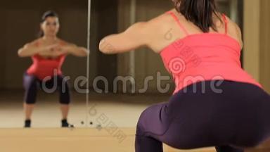 健身妇女在健身房做蹲式训练，锻炼腿部、臀部、臀部和大腿。 上蹲练习。