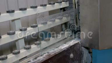 一片玻璃从机器里出来处理边缘。 工厂用于生产窗户。