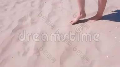 女孩光着脚在沙滩上散步，在海边度假，脚在沙滩上。