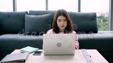 微笑的女人坐在沙发上放松，一边浏览网上<strong>购物网站</strong>。