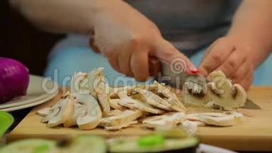 一个女人用一把刀在木板上把<strong>香瓜</strong>蘑菇切成薄片。