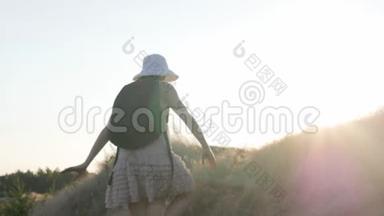 穿着<strong>漂亮衣服</strong>和背包的旅游妇女走在山顶上，看着地平线。 旅游经验