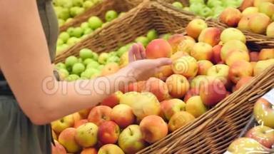 一个女人在<strong>蔬菜</strong>货架上的<strong>超市</strong>里买<strong>蔬菜</strong>和<strong>水果</strong>。 人类选择苹果。 慢动作，4k