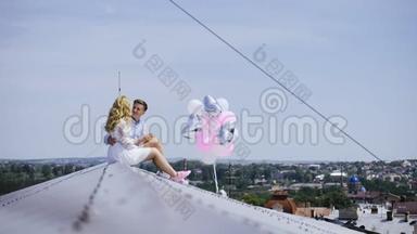 电影院。 年轻夫妇拿着<strong>气球坐</strong>在屋顶上