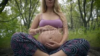 高加索孕妇，长着波西米亚风格的长发。大肚子上的白色麦亨迪。新时代的宝宝期待