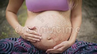 高加索孕妇，长着波西米亚风格<strong>的</strong>长发。大肚子上<strong>的</strong>白色麦亨迪。新时代<strong>的</strong>宝宝期待