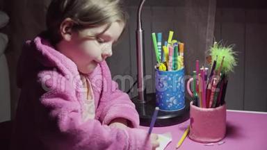 穿着粉红色浴袍的漂亮小女孩正在用<strong>彩色铅笔画</strong>插图。