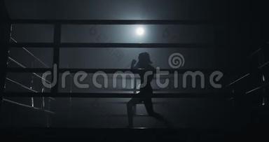 女拳击手在黑暗中训练。 慢<strong>动作</strong>。 <strong>剪影</strong>。 拳击概念