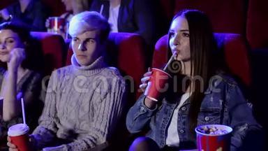一群青少年朋友在电影院看电影和吃爆米花。