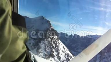从飞机驾驶舱拍摄的飞越白雪覆盖的高山的照片