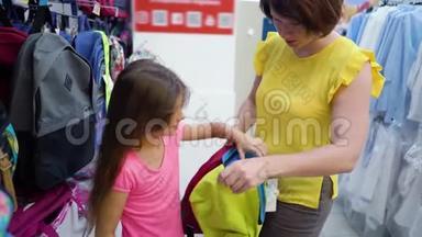 在哈伯达舍市场，白人母女在商店货架旁选择书包背包
