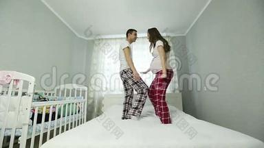 一个<strong>孕妇</strong>和一个穿<strong>睡衣</strong>的男人在床上跳舞。
