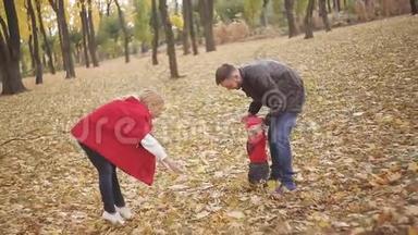 秋天在公园里散步的美丽家庭。 一个<strong>小孩</strong>学会和他的父母一起<strong>走路</strong>