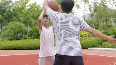 在花园里和爸爸一起打篮球时，亚洲的儿子在做抽水假动作