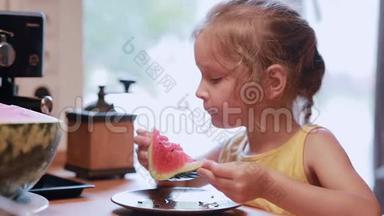 厨房里吃一片西瓜的<strong>可爱</strong>小女孩的肖像。 女转身，看着镜头笑了..