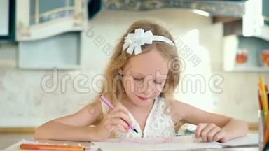 可爱的小女孩坐在桌子旁，用铅笔画画。