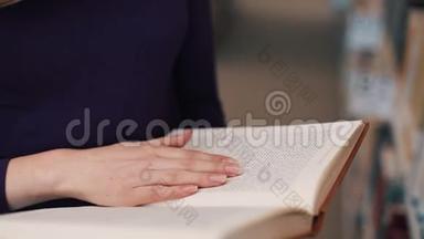 女孩把手指放在<strong>图书馆看书</strong>的书页上