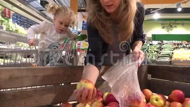 怀孕的母亲和女儿在购物中心买水果