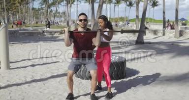 女人帮男人在海滩上锻炼