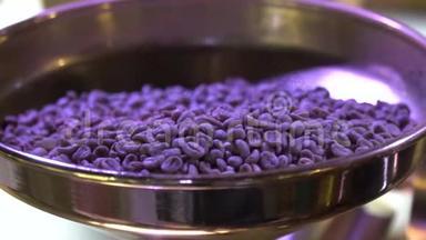 在紫外线下，咖啡豆从碗中倒入烘焙咖啡机