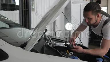 服务站，专业技工男站近敞篷检查接线汽车系统，发动机审查
