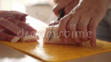 在塑料厨房板上切肉。 女手特写用刀切肉片..