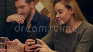 一对年轻<strong>夫妇</strong>用手机和芬妮<strong>自拍照</strong>片坐在咖啡馆里