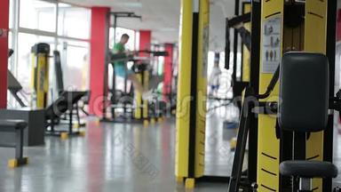 健身俱乐部的气氛，许多活跃的人在<strong>运动器材</strong>上锻炼