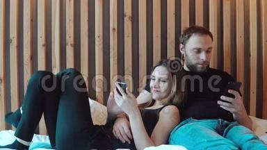 一对年轻夫妇把智能手机<strong>放在地板</strong>上。 男人和女人用小玩意花时间，互相交谈。