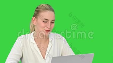 年轻的女商人与合伙人在线交谈，使用笔记本电脑上的绿色屏幕，铬键。