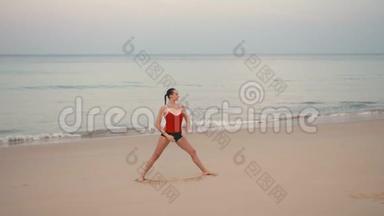 日出前在海滩上穿<strong>红色运动</strong>服的女人练习瑜伽健身<strong>运动</strong>