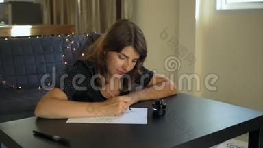 一位年轻女子用刻字技巧在纸上书写书法的特写镜头。 她写着<strong>梦</strong>想