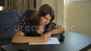 一位年轻女子用刻字技巧在纸上书写书法的特写镜头。 她写着梦想