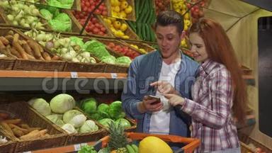 情侣们在超市讨论智能手机上的<strong>购物清单</strong>
