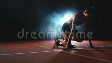 黑暗<strong>背景</strong>下的女运动员正准备从跑步机上的垫子上进行越野<strong>冲刺</strong>