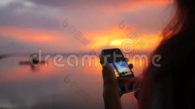 年轻的少女厌恶照片美丽的日落手机。 高清慢速运动。 泰国。