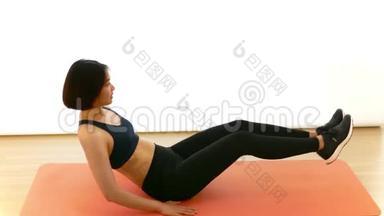 在白色背景的健身节目中，漂亮的泰国女孩正在做腿部<strong>按压</strong>或V紧缩仰卧起坐锻炼