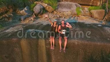 年轻夫妇坐在岩石悬崖上，用<strong>飞行</strong>四方直升机<strong>无人</strong>机制作<strong>飞行</strong>自拍视频。 西米兰，泰国。